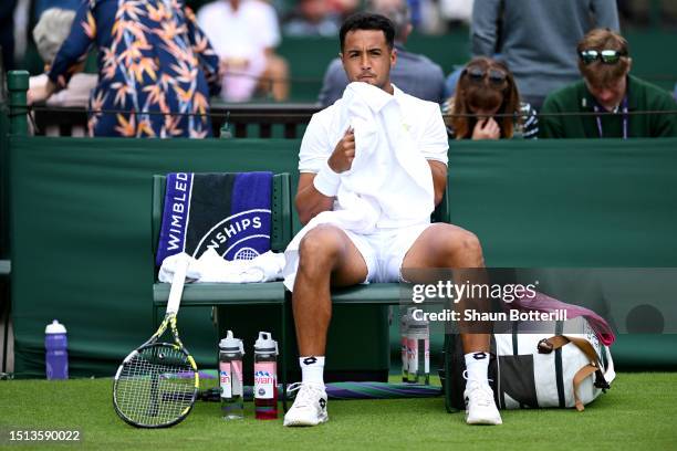 Hugo Dellien of Bolivia takes a break against Marcos Giron of United States in the Men's Singles first round match during day two of The...