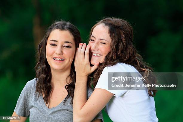 sisters laughing and telling secret - jennifer kelly stock pictures, royalty-free photos & images