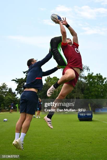 Freddie Steward of England rises to claim the high ball under pressure from Kevin Sinfield, Defence Coach of England during a training session at The...