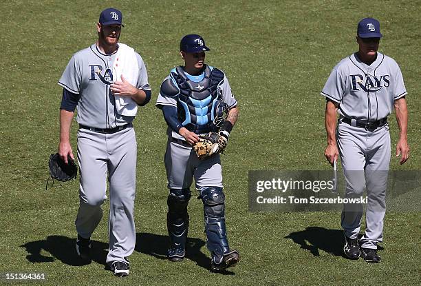 Jeff Niemann of the Tampa Bay Rays and Jose Lobaton and pitching coach Jim Hickey make their way from the bullpen to the dugout before MLB game...