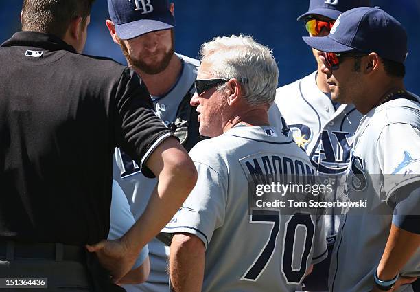 Jeff Niemann of the Tampa Bay Rays exits the game in the fourth inning as manager Joe Maddon talks to him on the mound as Carlos Pena watches during...