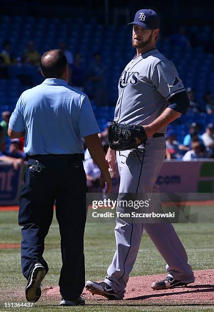 Jeff Niemann of the Tampa Bay Rays gets a visit by the trainer to tend to an injury in the fourth inning during MLB game action against the Toronto...