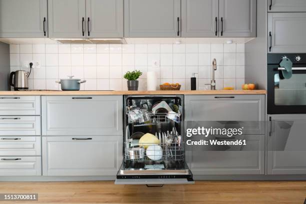 dishes inside dishwasher in kitchen at home - dishwasher stock pictures, royalty-free photos & images