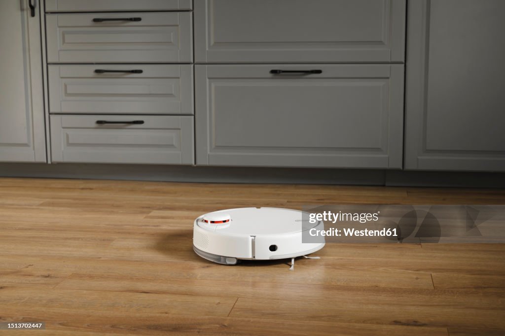 Robot vacuum cleaner near drawers at home