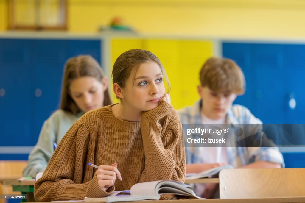 Pensive teenage girl sitting in the classroom