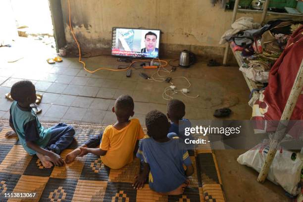 Displaced children who fled the ongoing violence by two rival Sudanese generals, watch television in a room inside the university of Al-Jazira,...