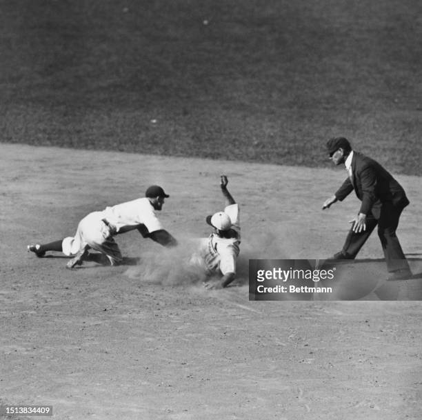 Cardinals' Pepper Martin makes it safely to 2nd base against Charlie Gehringer from the Detroit Tigers, during the 1934 World Series tournament,...
