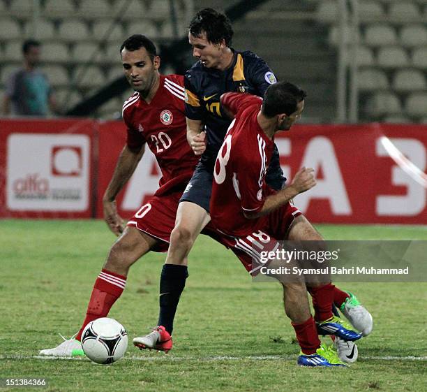 Robbie Kruse of Australia fights for the ball with Walid Ismail and Roda Antar of Lebanon during the International Friendly match between Lebanon and...