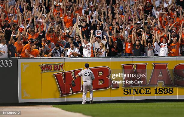 Left fielder Raul Ibanez of the New York Yankees looks on as fans celebrate a three RBI home run hit by Matt Wieters of the Baltimore Orioles during...