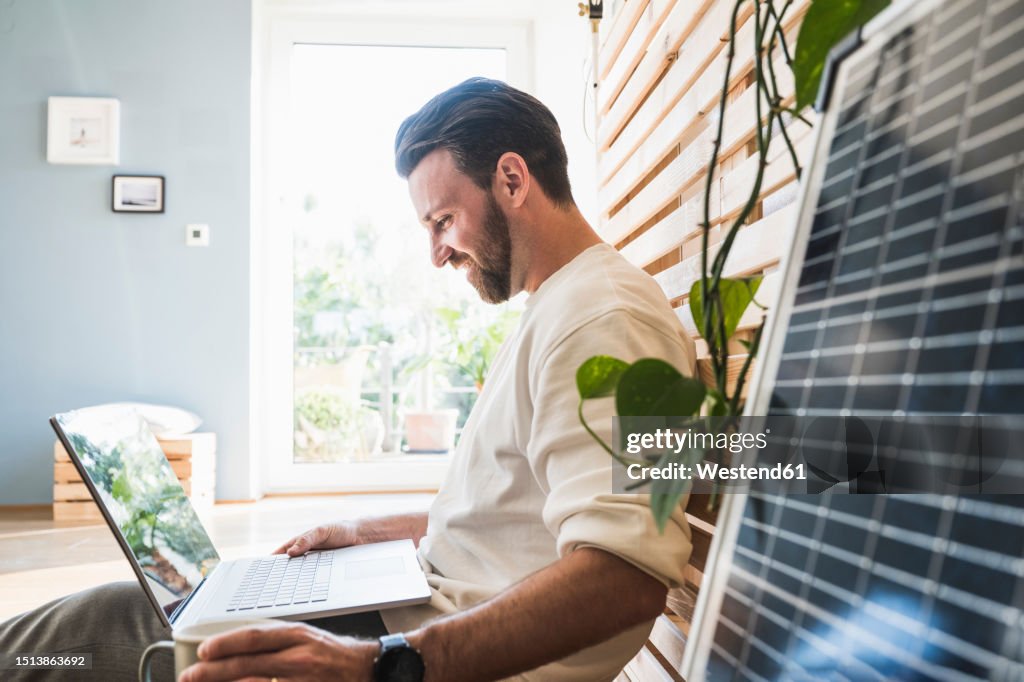 Happy businessman working on laptop at home