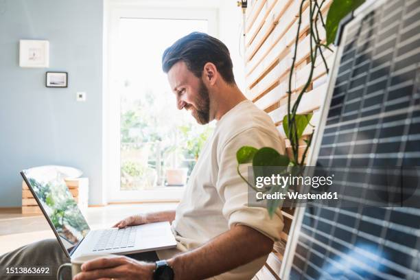 happy businessman working on laptop at home - autarkie stockfoto's en -beelden