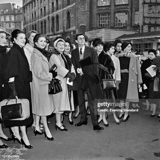 French fashion designer Yves St Laurent poses with a group of fashion models after arriving at Victoria Station in London, November 11th, 1958. St...