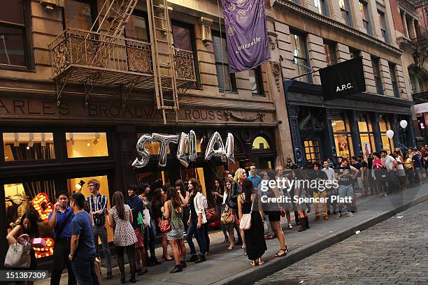 People walk down the street in SoHo during the fourth annual Fashion Night Out on September 6, 2012 in New York City. Fashion Night Out, which...