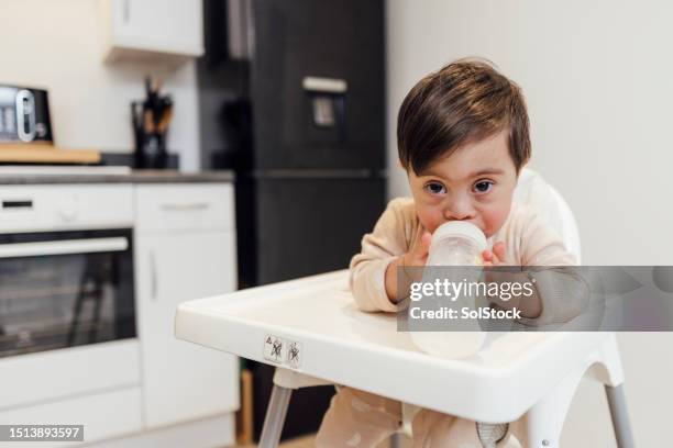 feeding from milk bottle - developmental disability stock pictures, royalty-free photos & images
