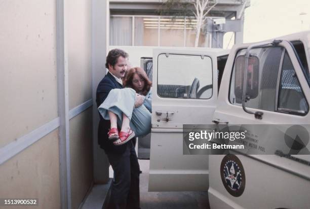 Lynette 'Squeaky' Fromme being carried from a van to a Federal Courthouse holding cell in Sacramento during her trial, November 17th 1975.
