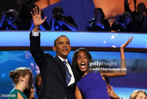 Democratic presidential candidate, U.S. President Barack Obama waves on stage with Malia Obama after accepting the nomination during the final day of...