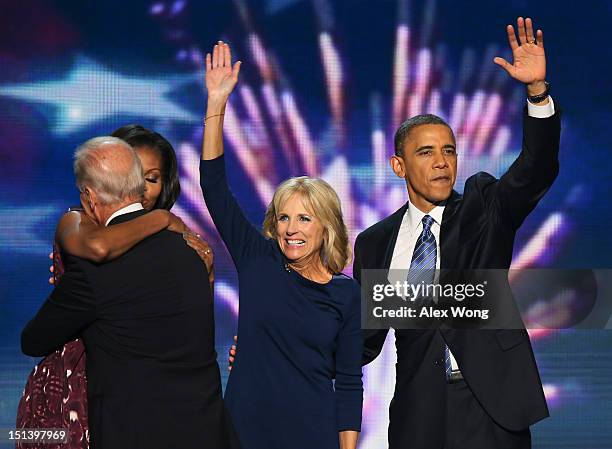 First lady Michelle Obama hugs Democratic vice presidential candidate, U.S. Vice President Joe Biden as Second lady Dr. Jill Biden waves with...