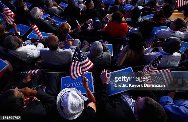 People listen as Democratic presidential candidate, U.S. President Barack Obama speaks on stage during the final day of the Democratic National...
