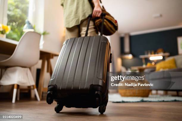 mujer irreconocible tirando de la maleta en el apartamento - all people fotografías e imágenes de stock