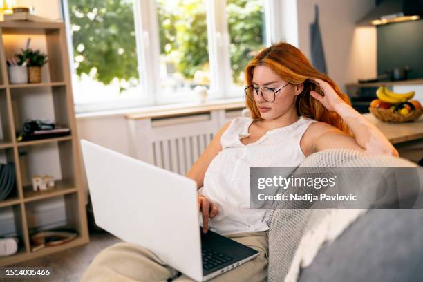 redhead woman with vitiligo and acne on her face, using laptop - interface dots stock pictures, royalty-free photos & images
