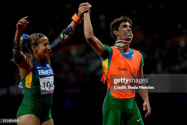 Terezinha Guilhermina of Brazil and her guide Guilherme Soares de Santana celebrate a victory and the gold medal in the Women's 100m - T11on day 7 of...