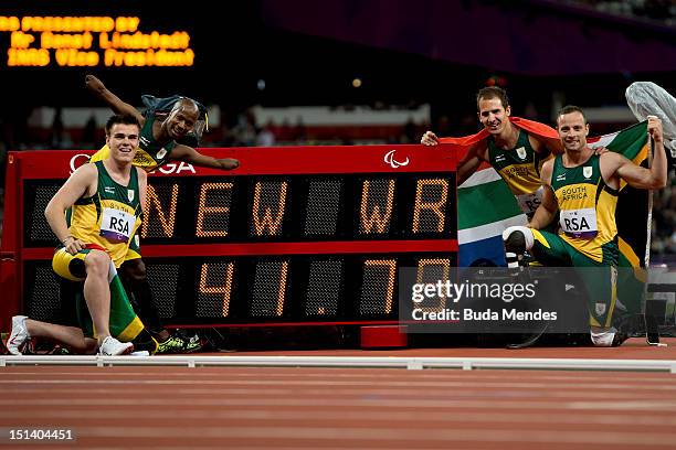 Zivan Smith, Samkelo Radebe, Arnu Fourie and Oscar Pistorius of South Africa pose with the timer showing their new world record after victory in the...