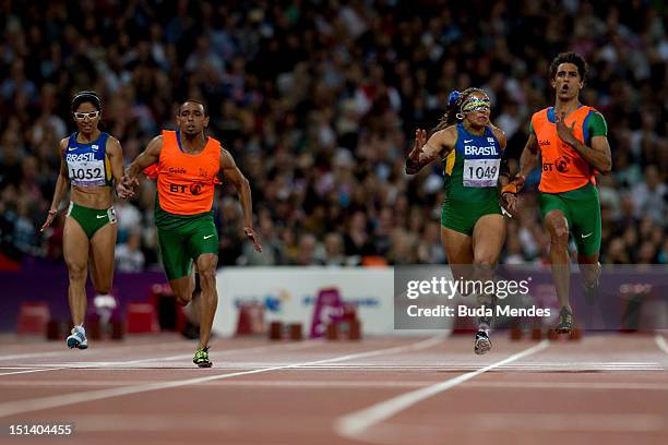 Terezinha Guilhermina of Brazil and guide Guilherme Soares de Santana cross the line to win gold ahead of silver medallists Jerusa Gerber Santos of...