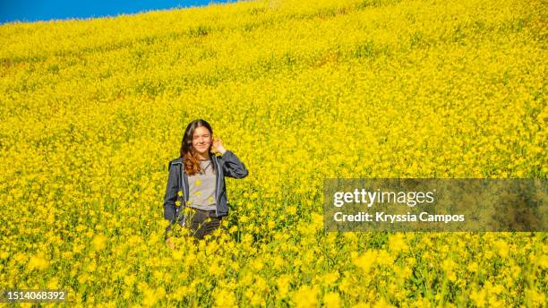 carefree teenage girl enjoying summer in yellow flowered field - cartago province stock pictures, royalty-free photos & images