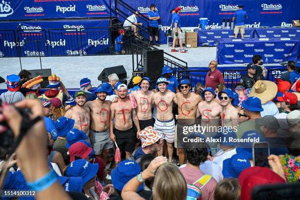 Spectators pose for a photo ahead of the 2023 Nathan's Famous Fourth of July International Hot Dog Eating Contest at Coney Island on July 04, 2023 in...