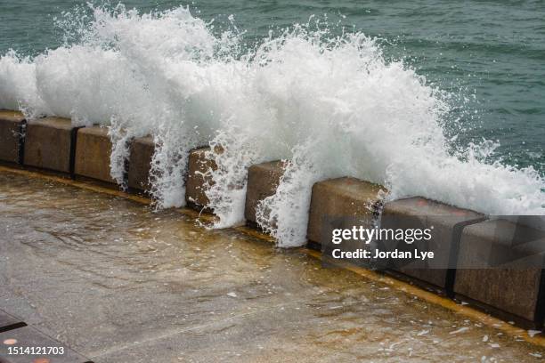 rough sea on retaining wall by sea - marée haute photos et images de collection