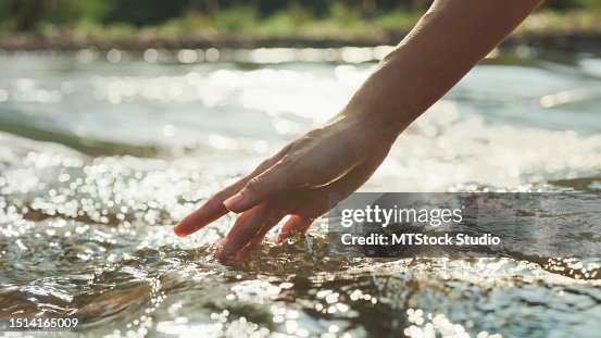 Nahaufnahme Frau berührt Wasser im Waldfluss im Urlaub mit Camping am Morgen. Lifestyle Reisen Natur. Nahaufnahme Frau berührt Wasser im Waldfluss im Urlaub mit Camping am Morgen. Lifestyle Reisen Natur.