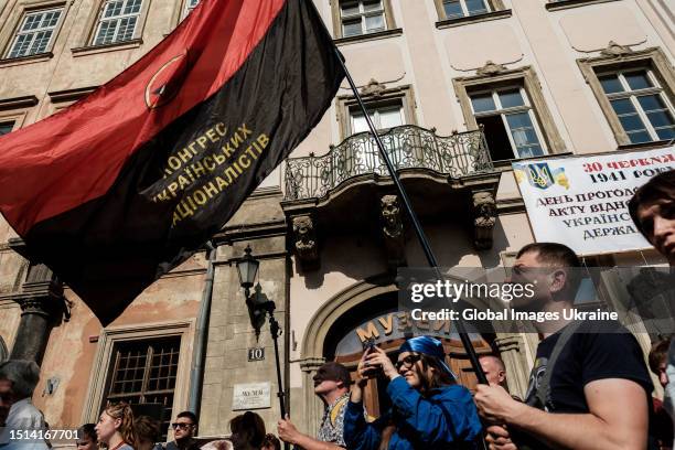 Man holds the black and red flag of the Congress of Ukrainian Nationalists during the anniversary of the proclamation of the Act of Ukrainian State...