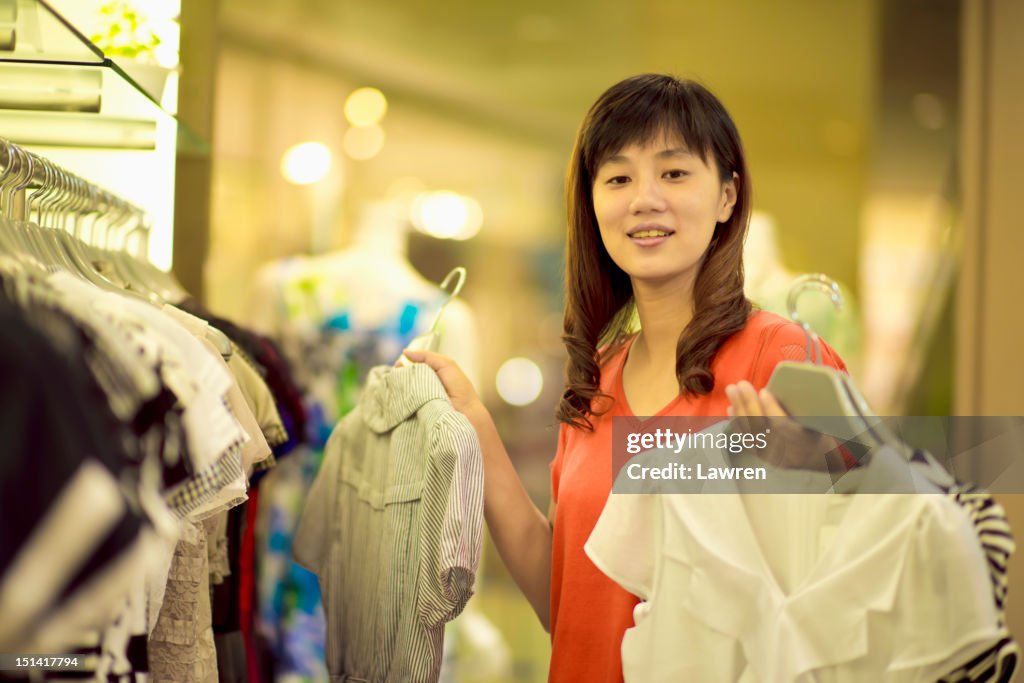 Woman chooses dresses in store