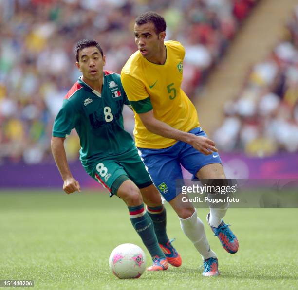 Sandro of Brazil with Marco Fabian of Mexico during the Men's Football Final between Brazil and Mexico on Day 15 of the London 2012 Olympic Games at...