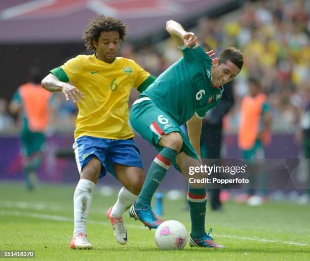 Marcelo of Brazil tackles Hector Herrera of Mexico during the Men's Football Final between Brazil and Mexico on Day 15 of the London 2012 Olympic...