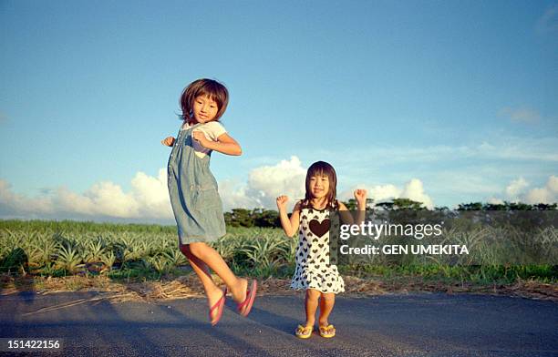 girls jumping - girls wearing sandals stock-fotos und bilder