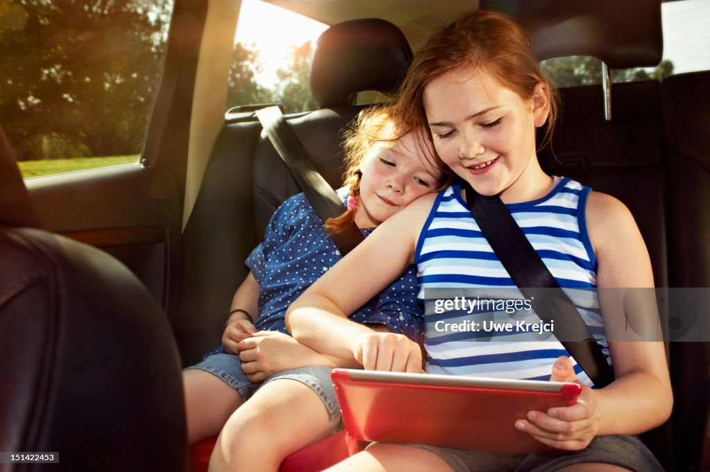 Two girls playing on digital tablet