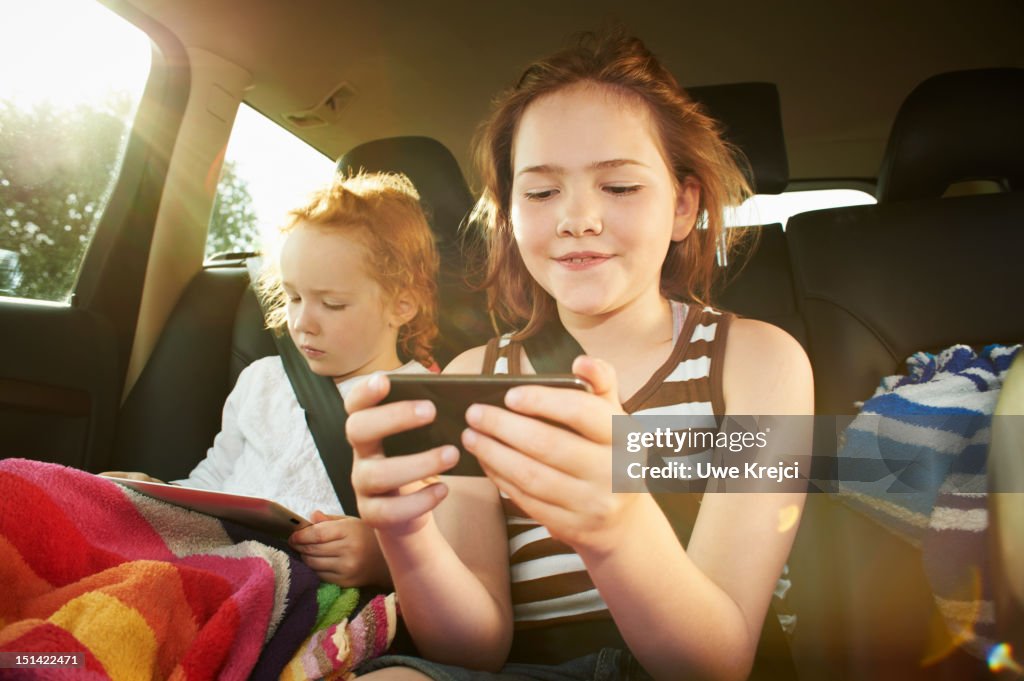 Two girls in rear seat of car