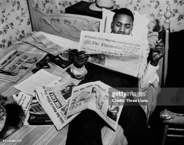 Oil heir Floyd Mayweather holds a lit cigarette as he reads a copy of 'The Plaiindealer' with the headline 'Mayweather Brothers Still Hold Jobs At...