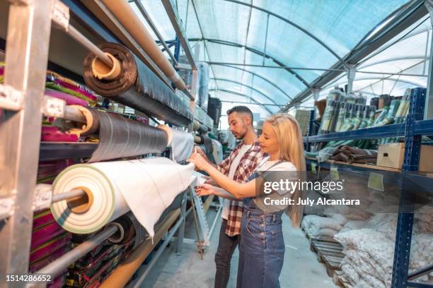 a young couple looking for garden furniture looking at fertilizers looking at concealment tarpaulins for their fence - tarpaulin 個照片及圖片檔