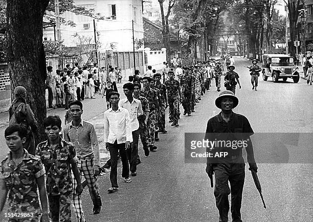 April 1975 photo shows a line of captured US-backed South Vietnamese Army soldiers, escorted by Vietnamese communist soldiers, as they walk on a...