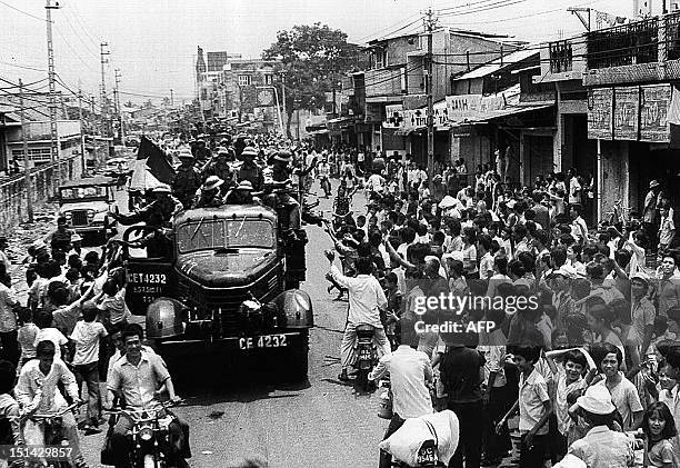 April 1975 photo shows Saigon residents taking to the street to welcome the arrival of communist troops on trucks 30 April 1975 after the fall of...