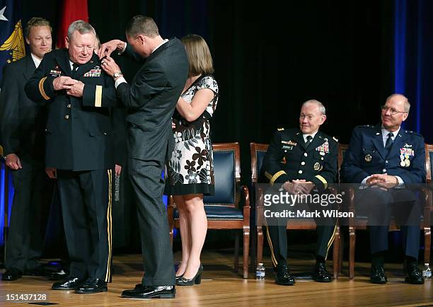 Family members help U.S. Army Lt. Gen. Frank Grass , change to four star epaulets, as Joint Chiefs Chairman Gen. Martin Dempsey , and U.S. Air Force...