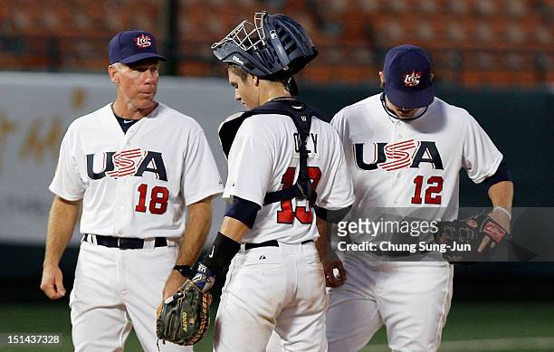 Kevin Davis, Chris Okey of United States talk with Scott Brosius, manager of United States during the U18 Baseball World Championship match between...