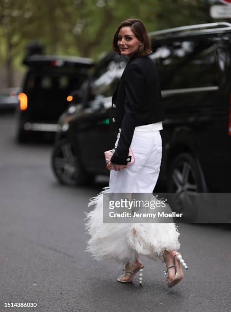 Olivia seen wearing a black blazer jacket with silver details, white jeans pants with fluffy fur details, white long shirt, silver high heels and a...