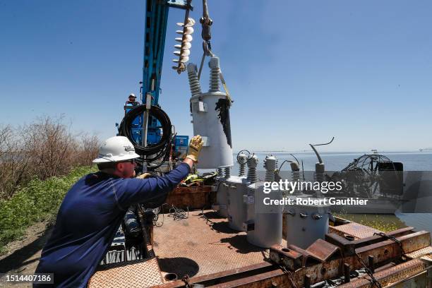 Corcoran, CA, Wednesday, May 10, 2023 - PG&E foreman Corey Wortham guides a transformer onto a truck as air boat crews remove transformers from the...