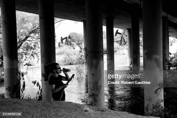 Bakersfield, CA, Tuesday, May 9, 2023 - A woman drinks from a vodka bottle as she passes time under the China Grade Loop bridge along the Kern River...