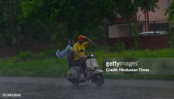 Commuters going through during the heavy rain, on July 8, 2023 in Chandigarh, India.