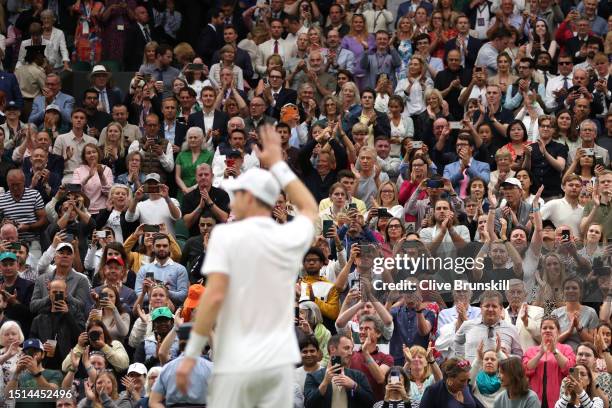 Fans applaud as Andy Murray of Great Britain celebrates winning match point against Ryan Peniston of Great Britain in the Men's Singles first round...