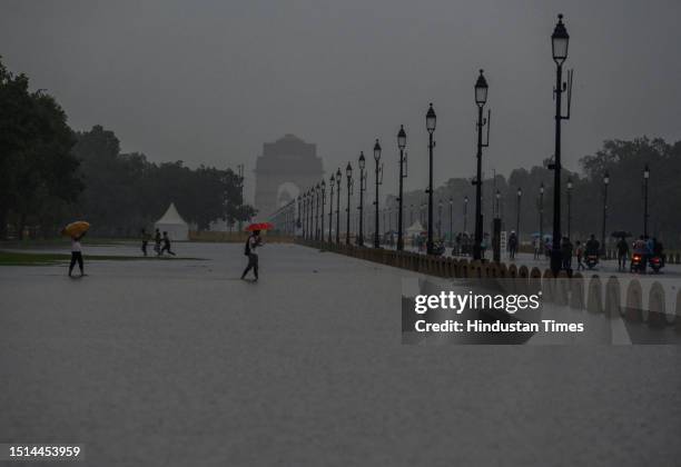 People walking through a water logged Central Vista Lawns after the Heavy rainfall at India Gate on July 8, 2023 in New Delhi, India. Delhi-NCR was...